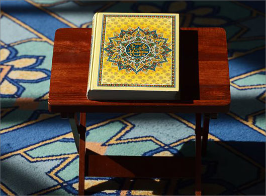 دانلود عکس با کیفیت از قرآن کریم روی میز و رحل چوبی در مسجد