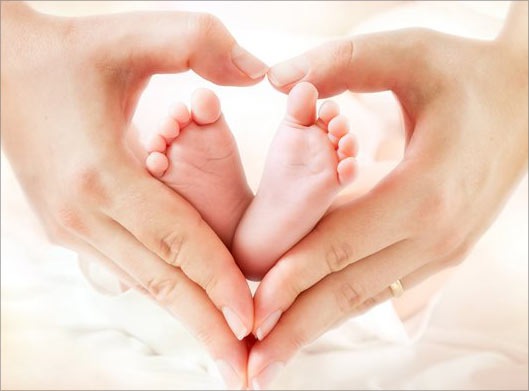 دانلود عکس با کیفیت از دست مادر به شکل قلب و پاهای نوزاد