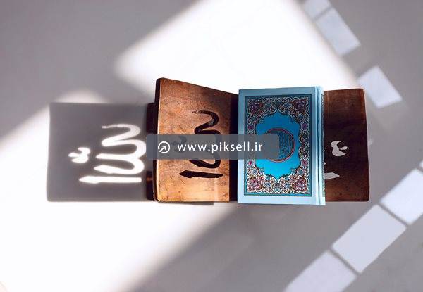تصویر با کیفیت از نمای بالای قرآن روی رحل چوبی