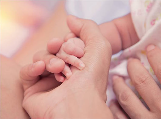 تصویر با کیفیت از دست نوزاد در دست مادر