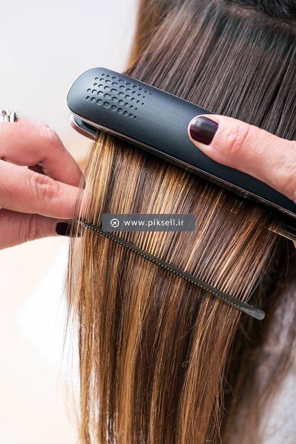 عکس با کیفیت از اتوی مو و شانه کردن مو در آرایشگاه زنانه