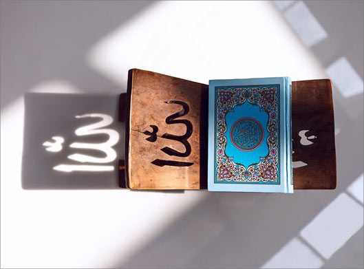 تصویر با کیفیت از نمای بالای قرآن روی رحل چوبی