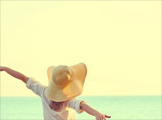 دانلود عکس با کیفیت از دختر جوان با کلاه در ساحل دریا