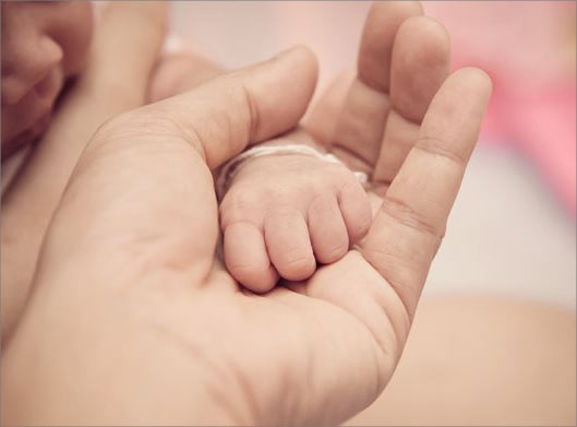 عکس با کیفیت از دست نوزاد در دست مادر