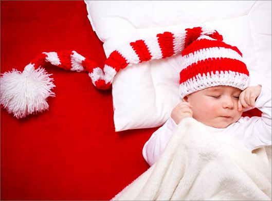 تصویر با کیفیت از نوزاد خوابیده با کلاه بلند قرمز