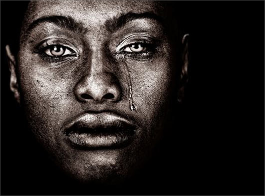 عکس با کیفیت از بکگراند سیاه و پرتره زن سیاهپوست در حال اشک ریختن
