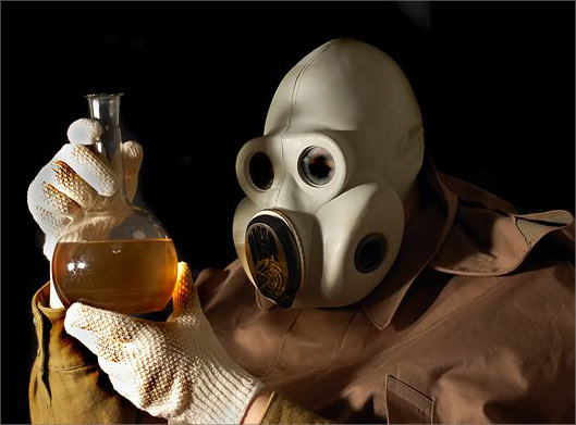 دانلود عکس با کیفیت از مرد شیمیدان و ماسک شیمیایی در حال بررسی محلول خطرنانک