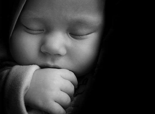 تصویر با کیفیت از نوزاد خوابیده با تم سیاه و سفید