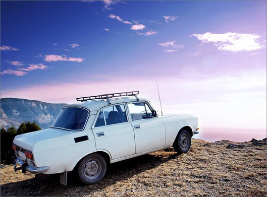 عکس با کیفیت از ماشین فیات قدیمی روی صخره و کوه و طبیعت