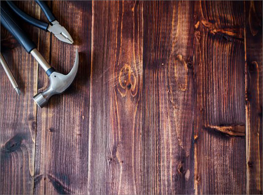 عکس با کیفیت از ابزارهای چکش ، انبردست و پیچ گوشتی روی میز چوبی