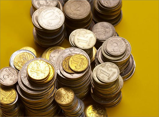 عکس با کیفیت از سکه های مختلف چیده شده روی هم با بکگراند زرد