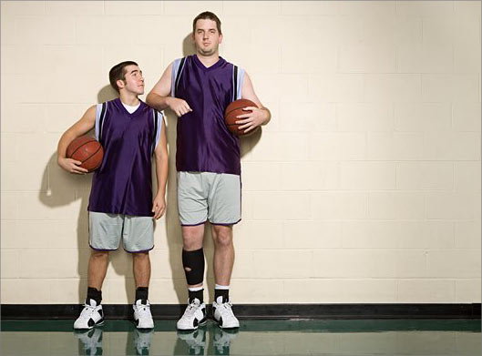 عکس با کیفیت از دو بازیکن قد بلند بسکتبال با توپ در دست