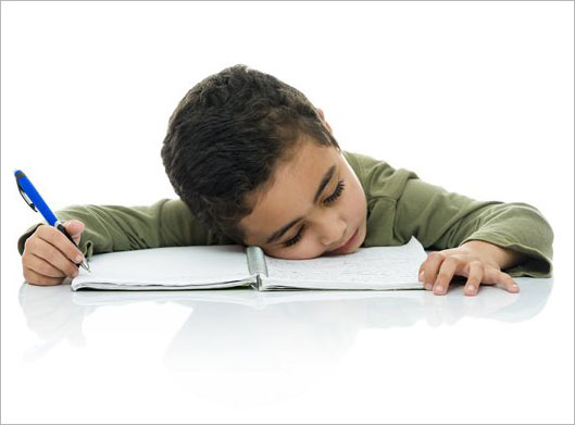 عکس با کیفیت از دانش آموز خسته خوابیده روی دفترچه مشق