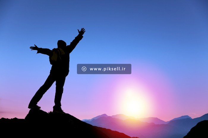 دانلود عکس شاتراستوک مرد در بالای کوه در غروب
