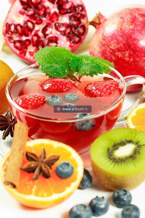 عکس با کیفیت از چای میوه ای شامل توت فرنگی ، انار و بلوبری