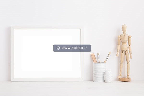 عکس با کیفیت از آدمک چوبی کنار تابلو و بنر سفید بدون متن