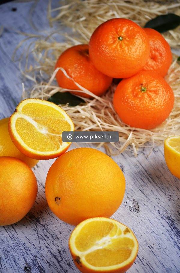 عکس با کیفیت از پرتقال و نارنگی روی پوشال ها