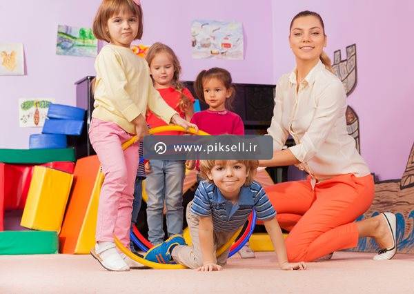 عکس با کیفیت از بازی با حلقه و معلم مهد در مهدکودک