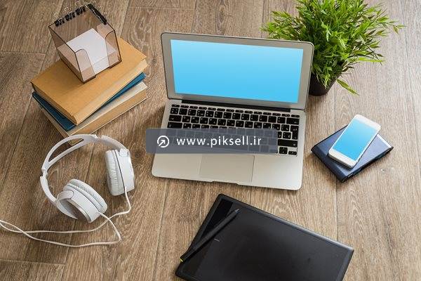عکس با کیفیت از میزکار با لپ تاپ هدفون و موبایل