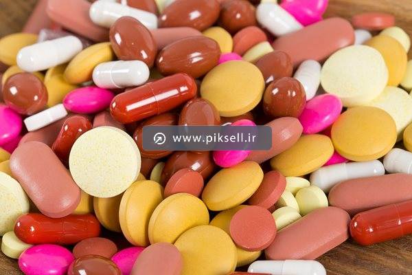 عکس با کیفیت از داروهای قهوه ای و زرد و قرص های رنگی