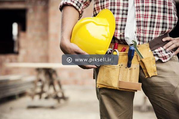 عکس با کیفیت از کارگر و کارگاه و کلاه ایمنی و ابزار در جیب