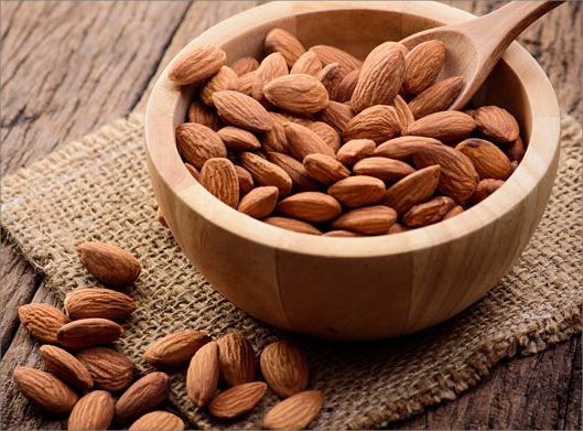 عکس با کیفیت از کاسه بادام و قاشق و مغز بادام