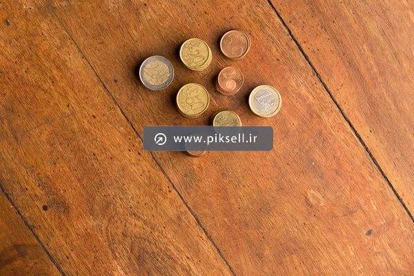 عکس با کیفیت از سکه های قدیمی پول روی میز چوبی