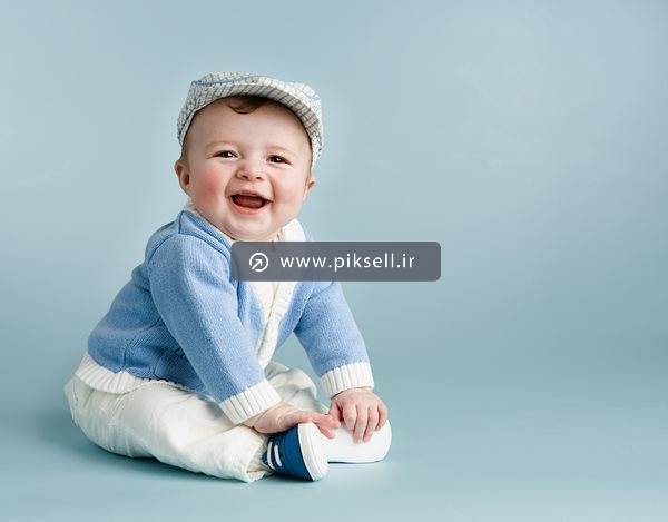 عکس با کیفیت از کودک خندان با پس زمینه آبی