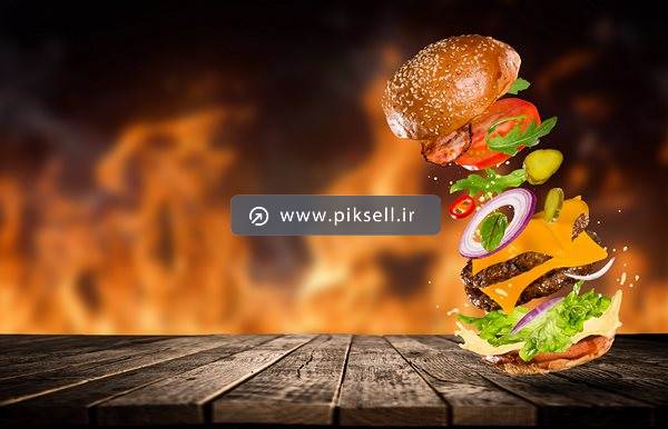 عکس با کیفیت از پس زمینه آتش و همبرگر روی میز