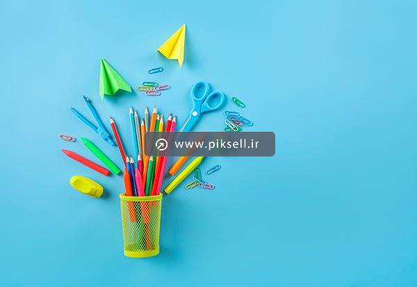 عکس با کیفیت از پس زمینه آبی و لوازم تحریر ، مداد و موشک کاغذی