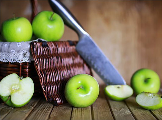دانلود عکس با کیفیت از سیب های سبز و سبد حصیری و چاقو