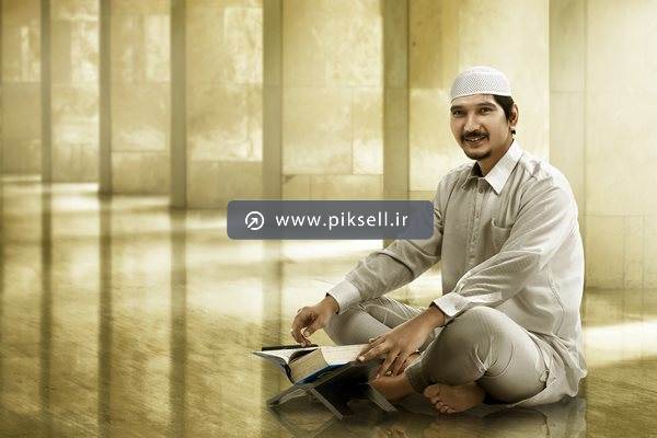 دانلود عکس با کیفیت از مرد مسلمان در صحن مسجد در حال خواندن قرآن