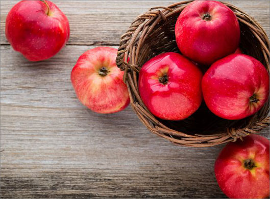 عکس با کیفیت از سبد حصیری و سیب های قرمز