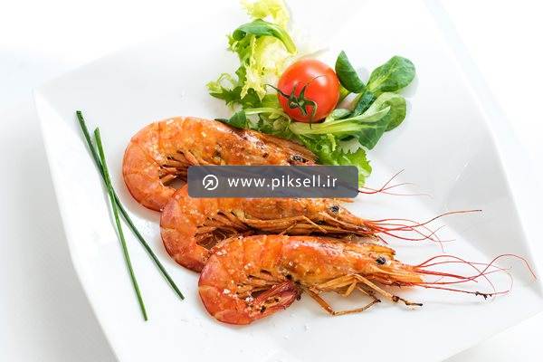 تصویر با کیفیت از میگوهای سوخاری در بشقاب و کاهو و گوجه