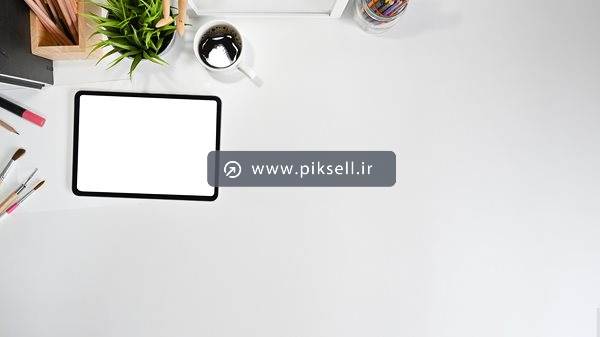 عکس با کیفیت از تبلت با صفحه سفید در کنار فنجان ، گلدان ، خودکار و ...