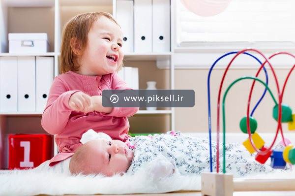 عکس با کیفیت از دختربچه شاد و برادر نوزاد