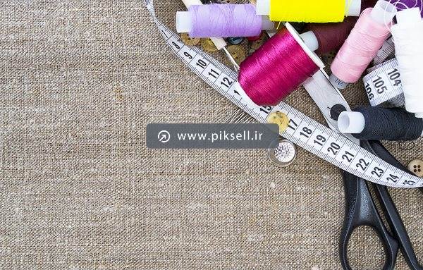 تصویر با کیفیت از نخ های خیاطی ، قیچی و متر و پارچه