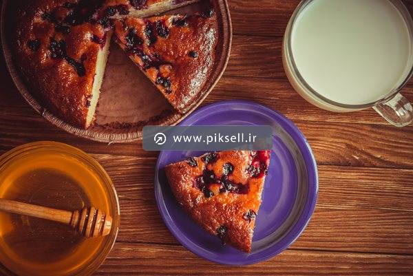 عکس با کیفیت از نمای بالای میز صبحانه شامل شیر ، عسل و کیک