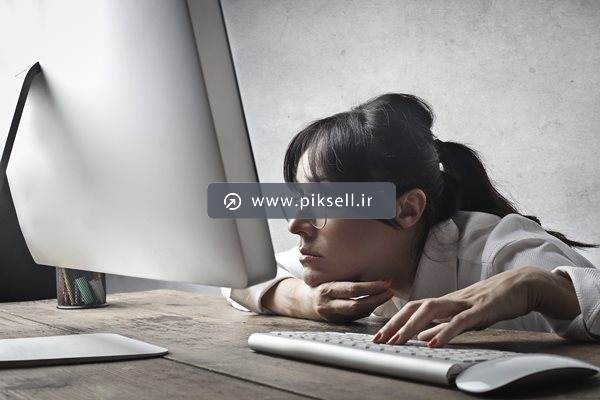 عکس با کیفیت از زن در حال زل زدن به لپ تاپ