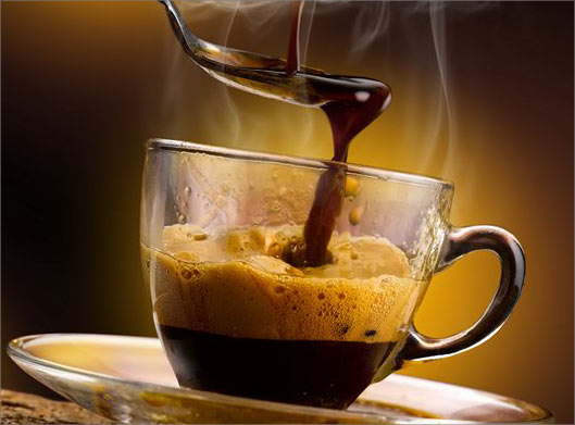 عکس با کیفیت از قاشق در فنجان شیشه ای قهوه داغ