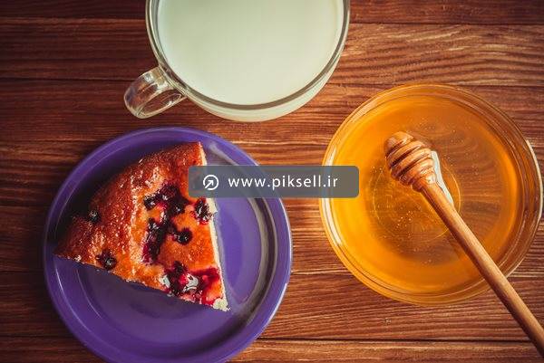 عکس با کیفیت از نمای بالای کیک و عسل و شیر