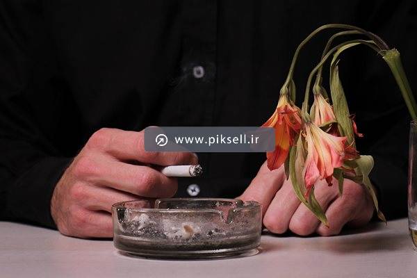 عکس با کیفیت از مرد سیگاری و جا سیگاری