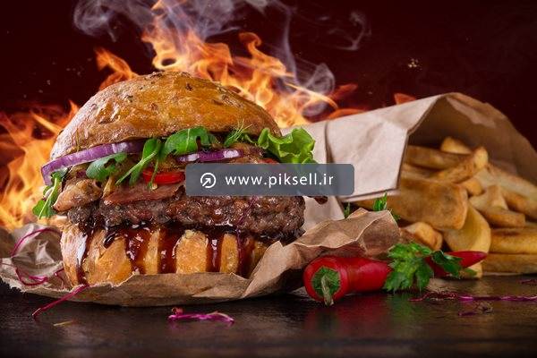 عکس با کیفیت از همبرگر گوشت و سیب زمینی سرخ شده و آتش