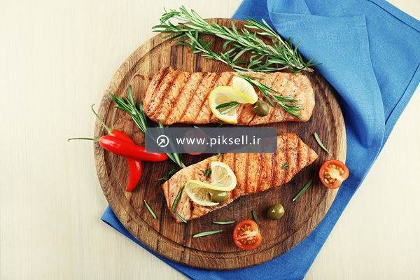 دانلود عکس با کیفیت از کباب مرغ و گوجه و فلفل قرمز روی تخته چوبی