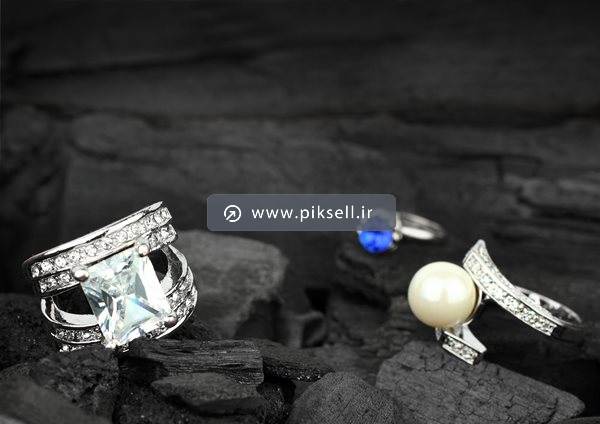 دانلود عکس با کیفیت از انگشتر و حلقه های نقره ای ازدواج روی سنگ های سیاه