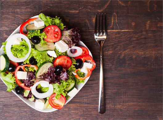 تصویر با کیفیت از بشقاب سالاد رژیمی و روی میز و چنگال