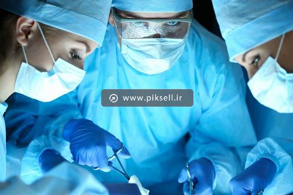 دانلود عکس با کیفیت از جراحان با روپوش آبی در حال عمل جراحی