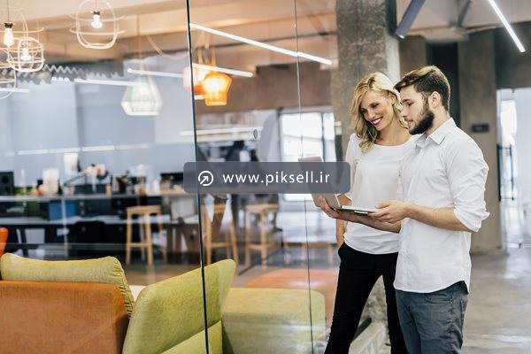 عکس با کیفیت از زن و مرد همکار در شرکت در حال بررسی طرح در لپ تاپ