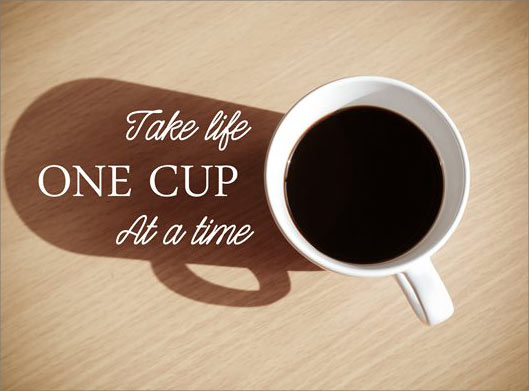 تصویر با کیفیت از فنجان قهوه با سایه روی میز و نوشته Take Life One Cup At A Time