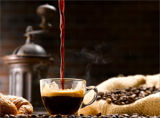 عکس با کیفیت از فنجان شیشه ای قهوه و دانه های قهوه